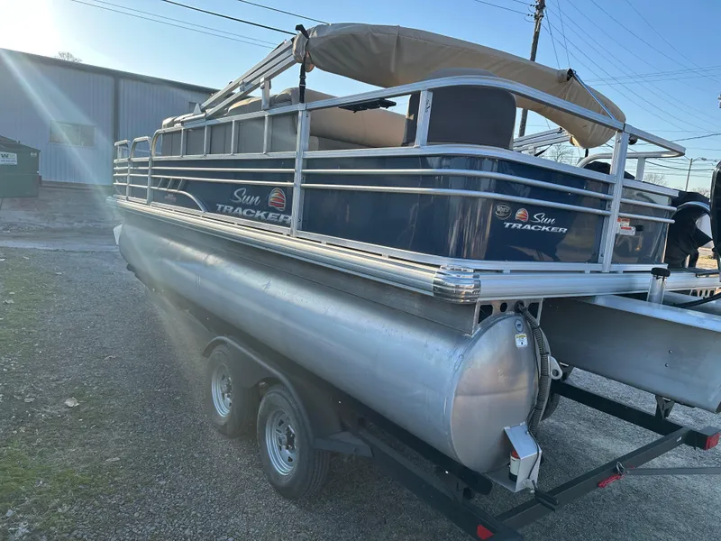 Slide: The Image of 2023 Sun Tracker Fishin' Barge 20 DLX pontoon boat on trailer, side view. - 4
