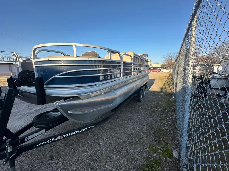 Slide: The Image of 2023 Sun Tracker Fishin' Barge 20 DLX pontoon boat on trailer, parked outdoors. - 6