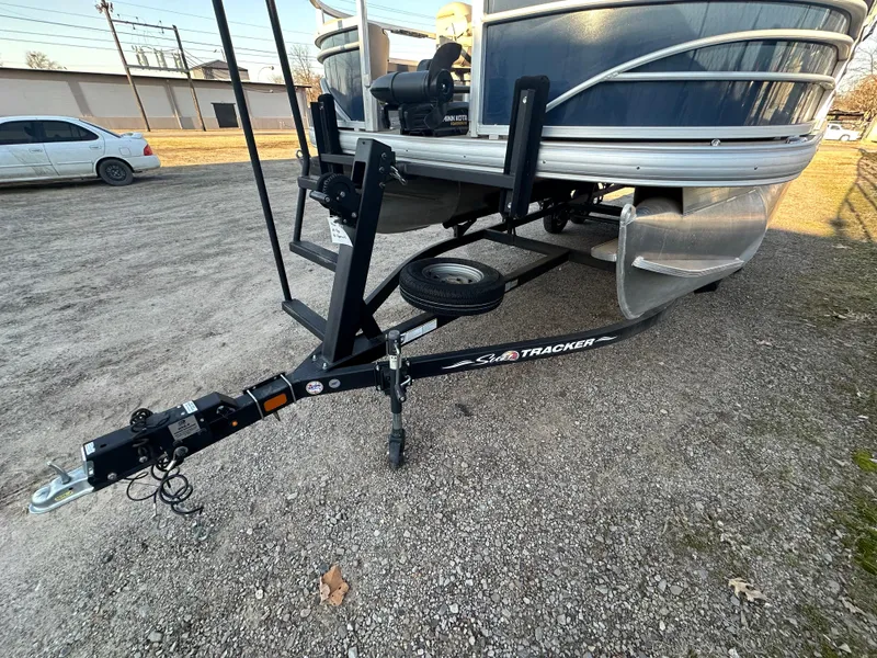 Slide: The Image of 2023 Sun Tracker Fishin' Barge 20 DLX on trailer, parked on gravel. - 7