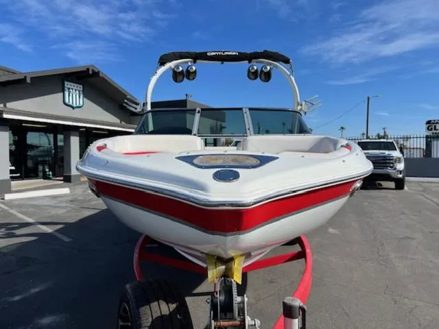 Slide: The Image of 2011 Centurion ENZO 240 boat on trailer, parked outside a building under a clear sky. - 3