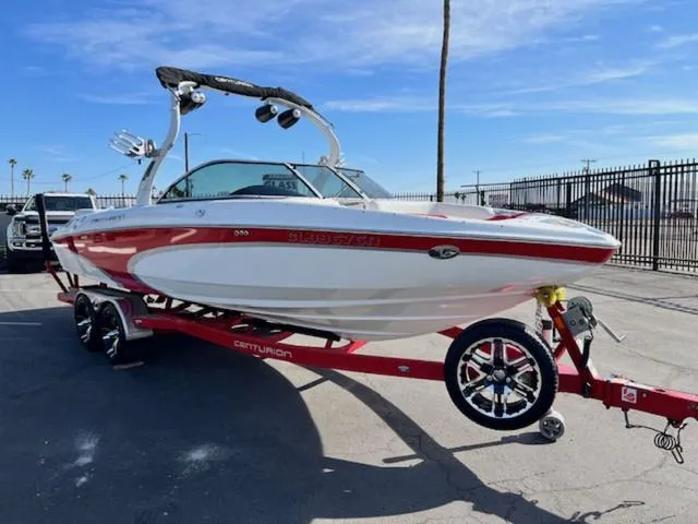 Slide: The Image of 2011 Centurion ENZO 240 boat on a red trailer, parked outdoors under a clear blue sky. - 4