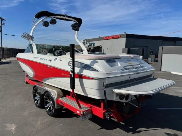Slide: The Image of 2011 Centurion ENZO 240 boat on trailer, red and white design, parked outdoors. - 9