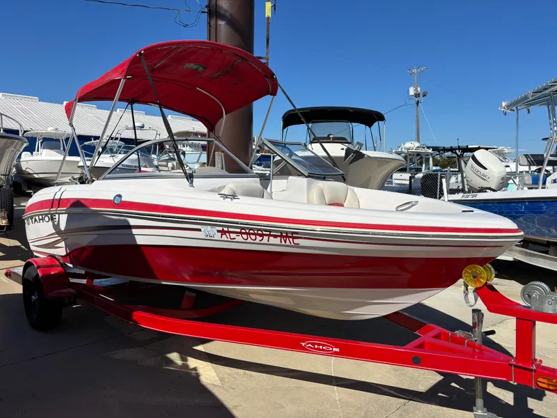 The Image of 2011 Tracker Tahoe Q5i boat with red and white design, parked on a trailer. - 0