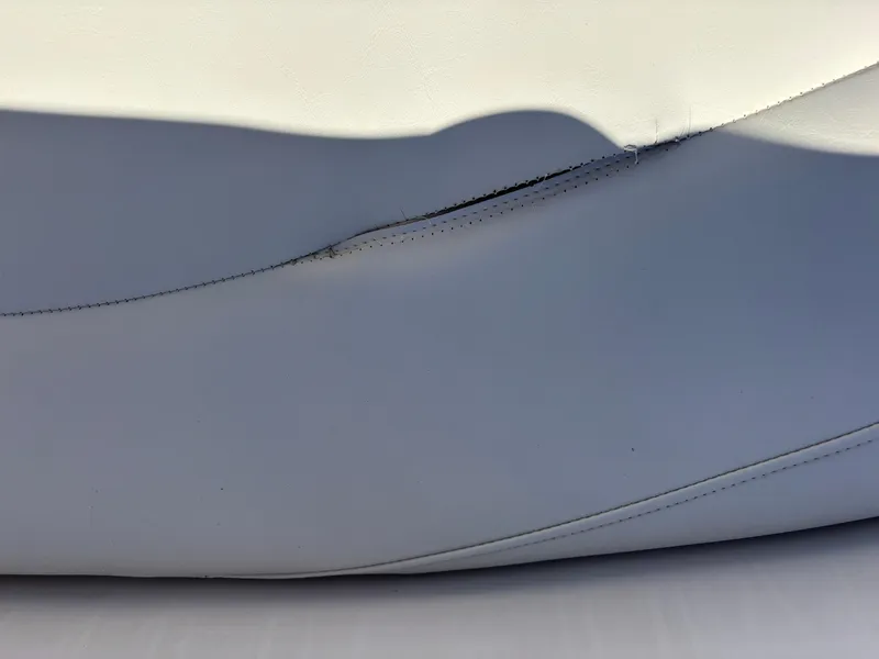 Slide: The Image of Close-up of a tear in white upholstery on a 2011 Tracker Tahoe Q5i boat seat. - 11