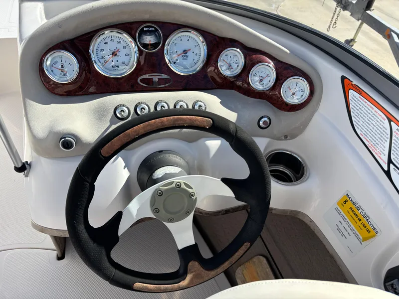 Slide: The Image of Steering wheel and dashboard of 2011 Tracker Tahoe Q5i boat, featuring gauges and controls. - 14