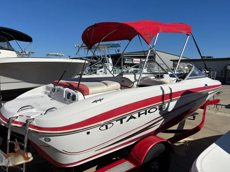 Slide: The Image of 2011 Tracker Tahoe Q5i boat with red canopy and trailer in a marina. - 33