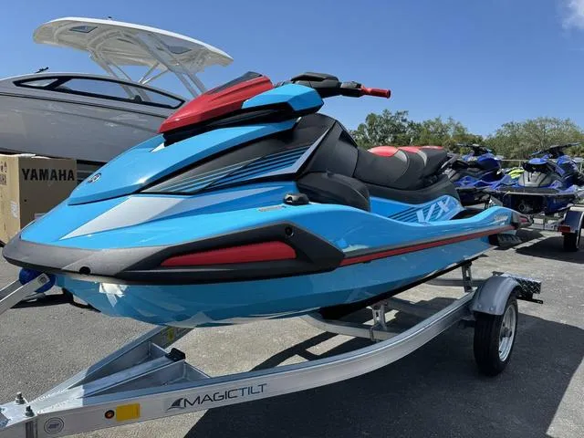 Slide: The Image of 2024 Yamaha Waverunner VX Deluxe with Audio in blue on trailer, parked outdoors. - 4