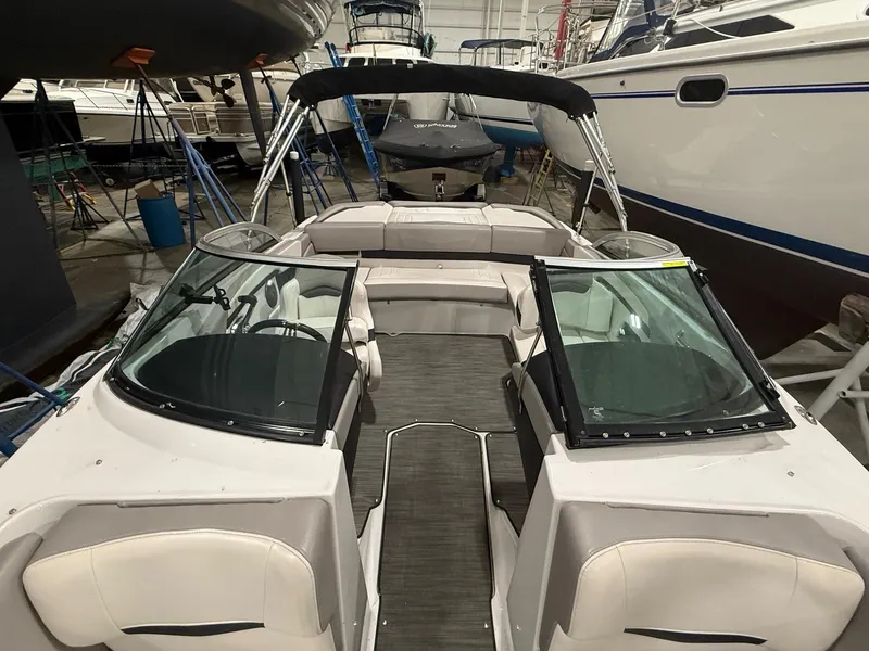 Slide: The Image of 2018 Four Winns H210 boat interior in a marina, featuring seating and windshield. - 20