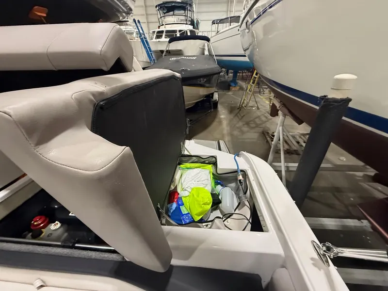 Slide: The Image of 2018 Four Winns H210 boat storage compartment open in a marina. - 26