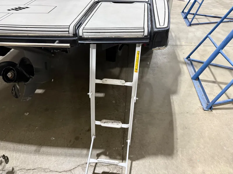 Slide: The Image of 2018 Four Winns H210 boat with extended swim platform and ladder in a garage setting. - 35