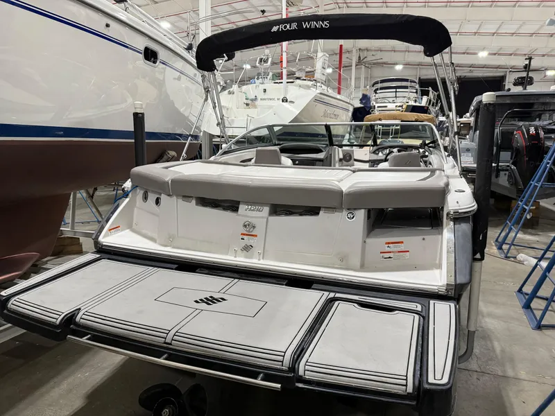 Slide: The Image of 2018 Four Winns H210 boat in a showroom, rear view with swim platform. - 6
