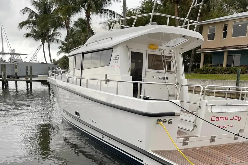Slide: The Image of Sargo 36 Fly 2015 boat docked near palm trees and waterfront homes. - 2
