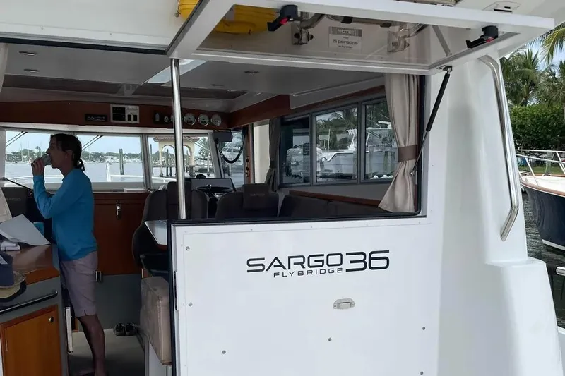 Slide: The Image of 2015 Sargo 36 Flybridge boat interior with person standing near helm. - 7