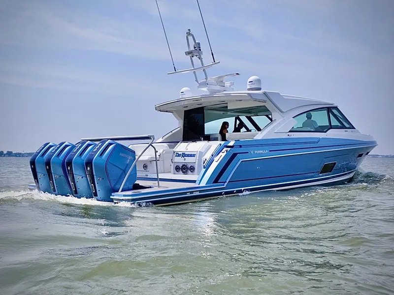Slide: The Image of 2023 Formula 500 Super Sport Crossover boat cruising on water with multiple outboard engines. - 11