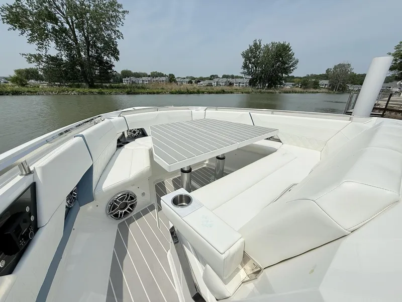 Slide: The Image of 2023 Formula 500 Super Sport Crossover boat interior with seating and table on a calm river. - 16