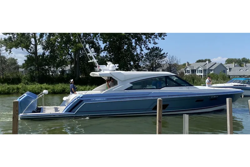 Slide: The Image of 2023 Formula 500 Super Sport Crossover boat on a calm river near houses. - 33