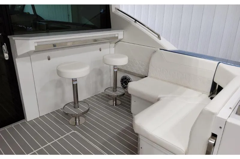 Slide: The Image of 2023 Formula 500 Super Sport Crossover interior with white seating and bar stools. - 47