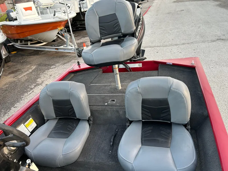 Slide: The Image of 2019 Tracker Pro 160 boat interior with three gray seats, parked outdoors. - 22