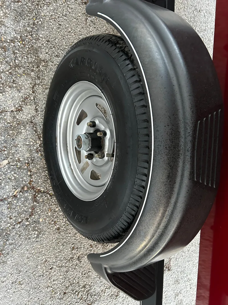 Slide: The Image of 2019 Tracker Pro 160 trailer wheel with fender on textured pavement. - 28