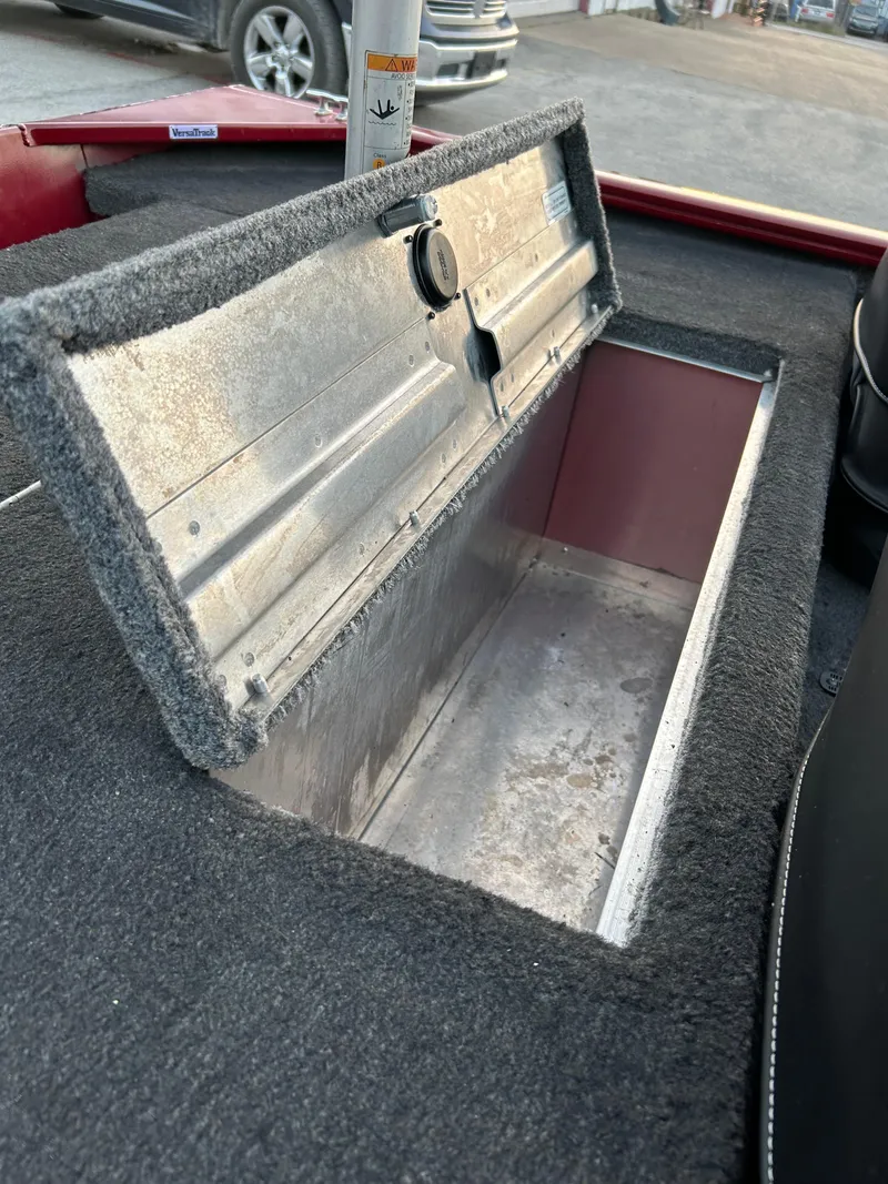 Slide: The Image of Open storage compartment in 2019 Tracker Pro 160 boat, featuring carpeted interior. - 41