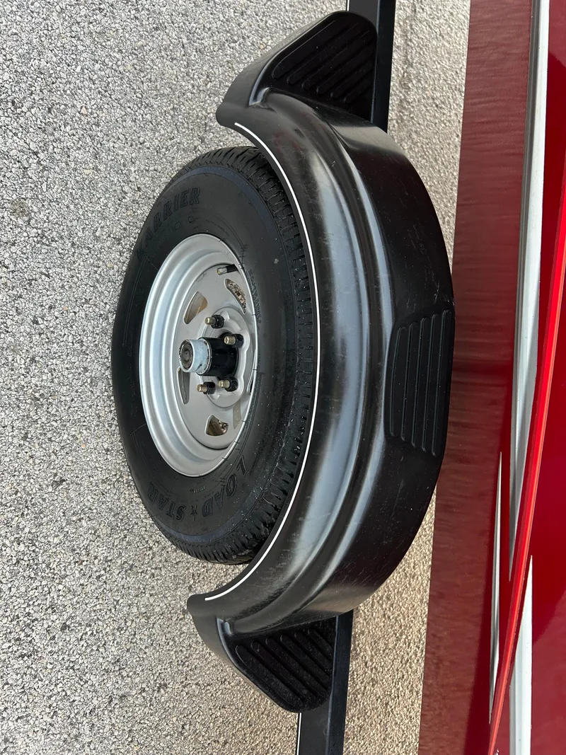 Slide: The Image of 2019 Tracker Pro 160 trailer wheel with black fender on textured surface. - 44