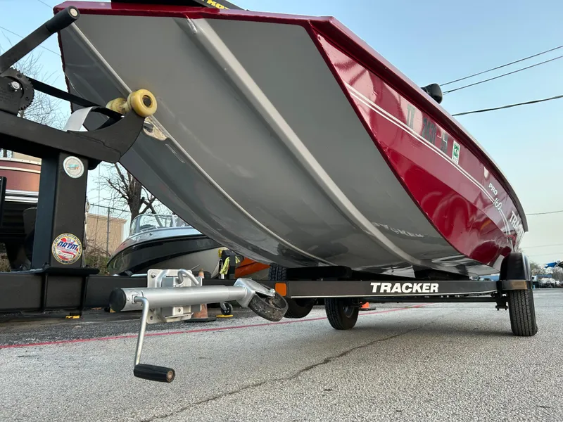 Slide: The Image of 2019 Tracker Pro 160 boat on trailer, red and gray hull, parked outdoors. - 45