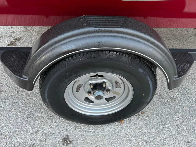 Slide: The Image of 2019 Tracker Pro 160 trailer wheel with black fender on asphalt surface. - 55