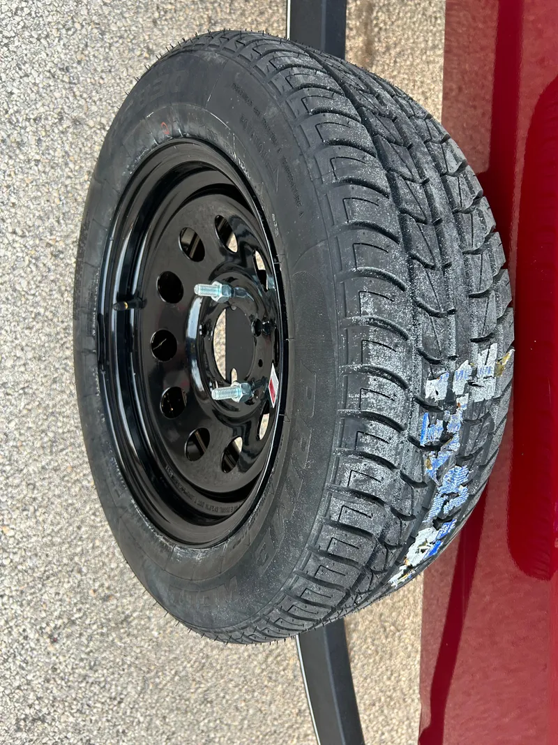 Slide: The Image of 2019 Tracker Pro 160 tire with black steel rim on pavement. - 56