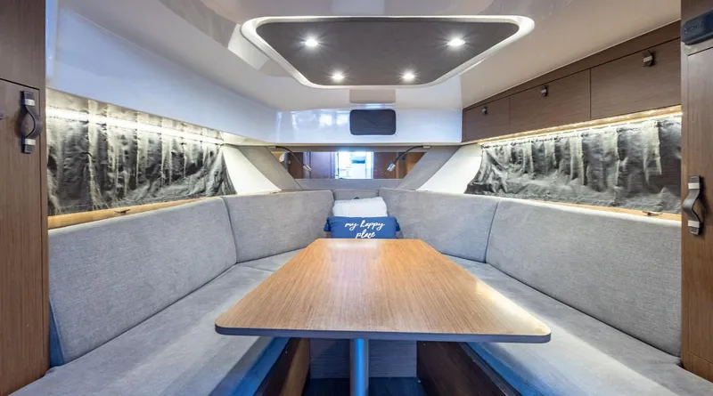 Slide: The Image of Interior of 2021 Beneteau Gran Turismo 32 yacht with cozy seating and wooden table. - 4
