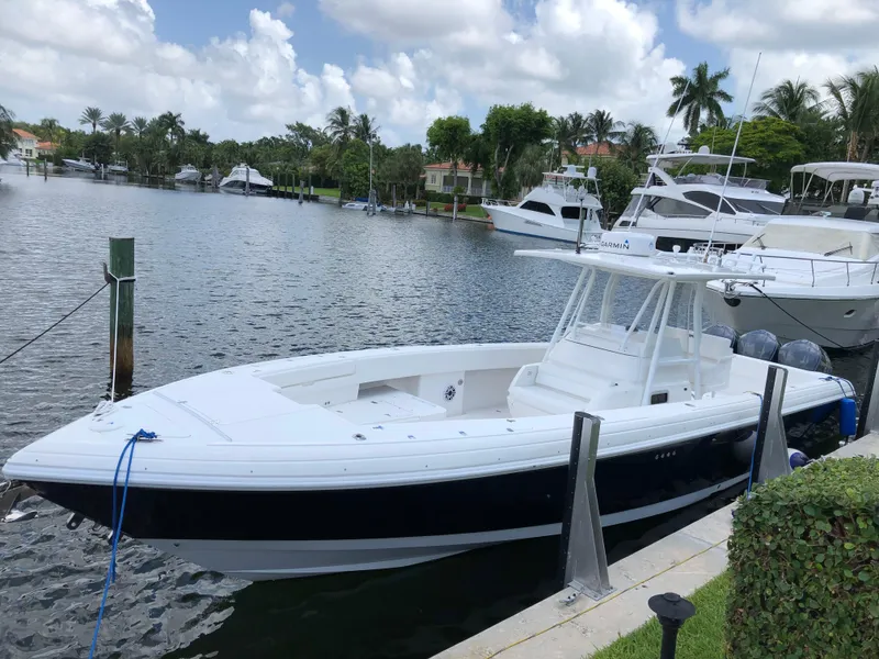 The Image of 2008 Intrepid 370 boat docked in a scenic marina with other yachts. - 1