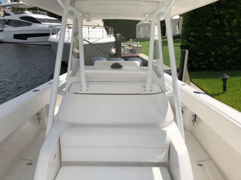 Slide: The Image of 2008 Intrepid 370 boat interior with white seating and docked yachts in the background. - 13