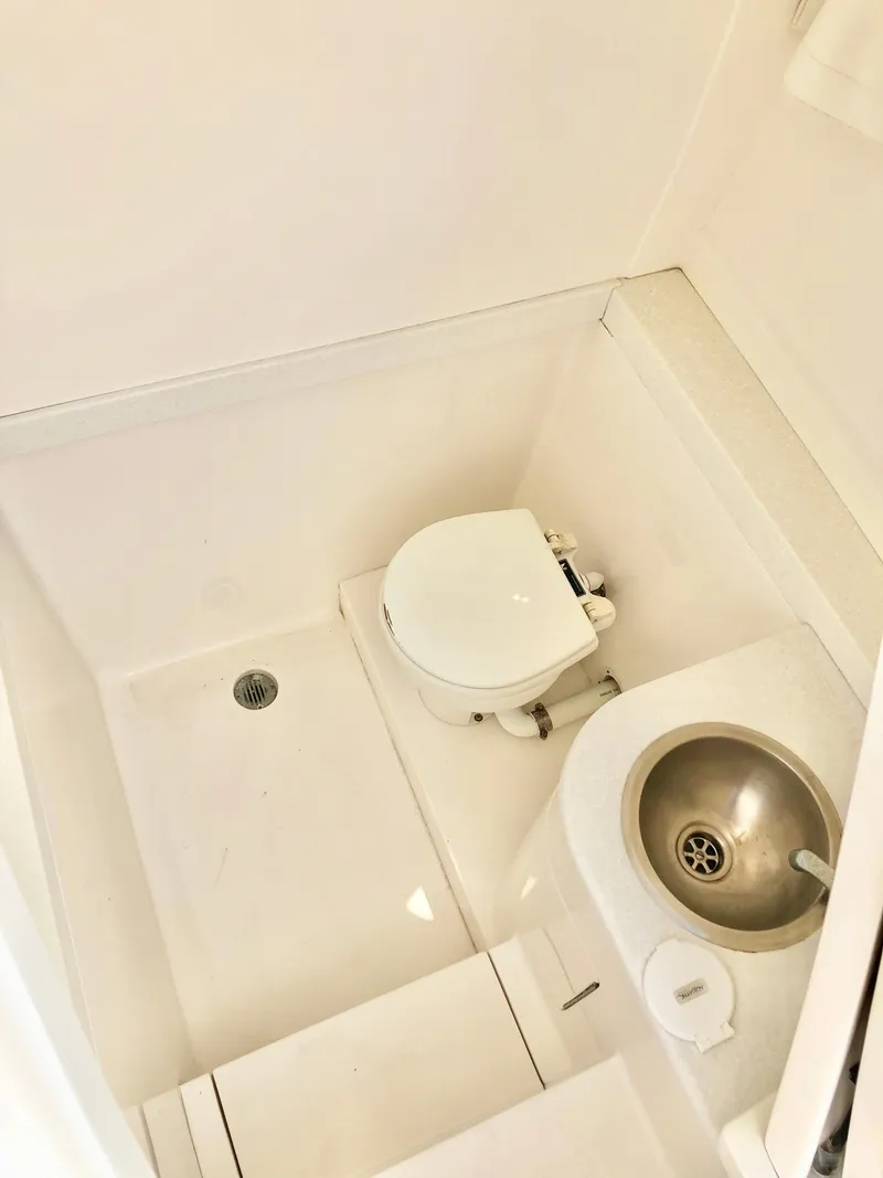 Slide: The Image of Compact bathroom in a 2008 Intrepid 370 boat, featuring a toilet and sink. - 19