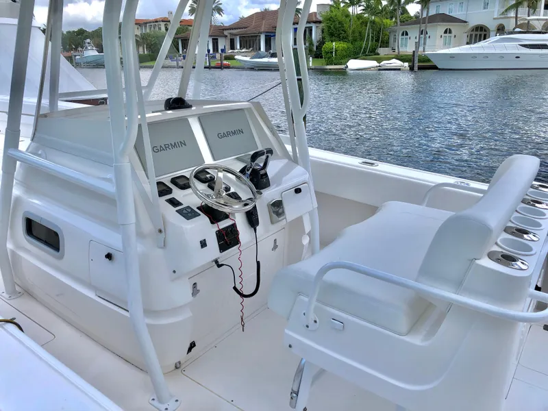 Slide: The Image of 2008 Intrepid 370 boat cockpit with Garmin navigation, docked by waterfront homes. - 5