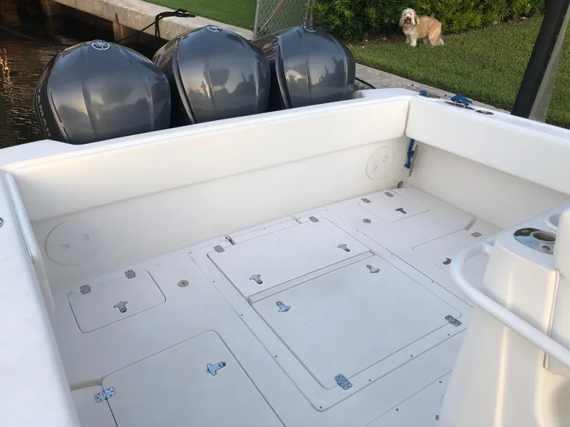 Slide: The Image of 2008 Intrepid 370 boat deck with triple outboard engines, docked near grassy area. - 6