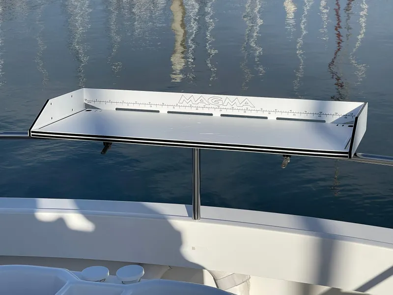 Slide: The Image of Magma cutting board on 2016 Farallon 3200 Explorer boat, reflecting on calm water. - 24