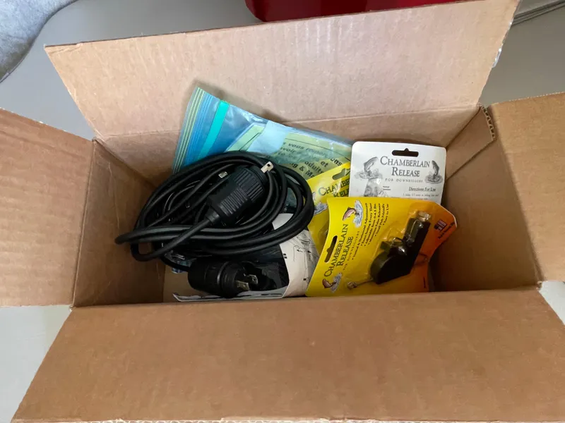 Slide: The Image of Open box with cables and Chamberlain garage door accessories. - 27
