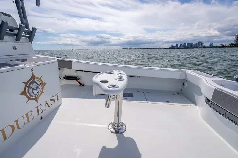 Slide: The Image of Freeman 42 boat deck with rod holders, ocean view, and city skyline in the background. - 45