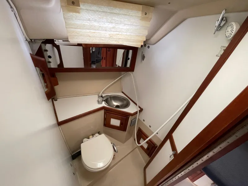 Slide: The Image of 1984 Catalina 30 yacht bathroom with sink, toilet, and wooden accents. - 10