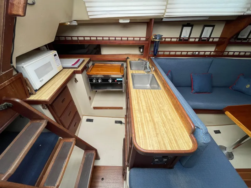 Slide: The Image of Interior of a 1984 Catalina 30 sailboat with kitchen and seating area. - 6