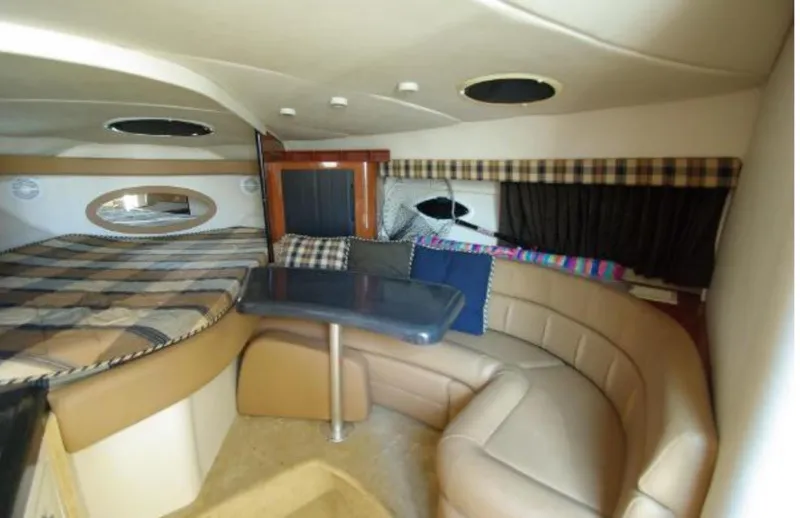 Slide: The Image of Interior of 2004 Monterey 322 Cruiser with cozy seating and plaid bedding. - 12