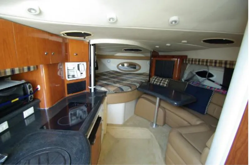 Slide: The Image of Interior of a 2004 Monterey 322 Cruiser, featuring a cozy cabin with kitchen and seating area. - 14