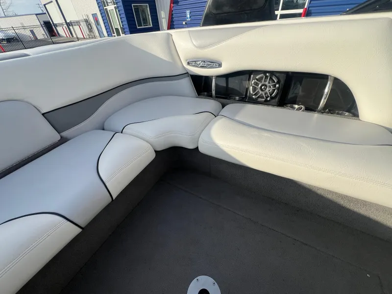 Slide: The Image of 2007 Malibu WVLX boat interior with white leather seating and built-in speaker system. - 13