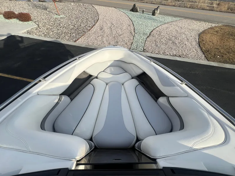 Slide: The Image of 2007 Malibu WVLX boat with white cushioned seating, parked on a paved driveway. - 15