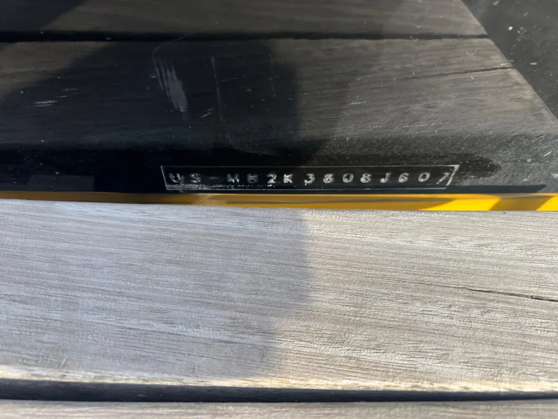 Slide: The Image of VIN number on a 2007 Malibu WVLX boat, displayed on a wooden surface. - 17