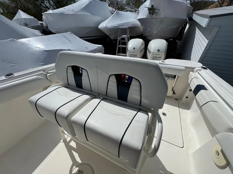 Slide: The Image of 2016 Wellcraft 252 Fisherman boat interior with white seating and covered boats in background. - 12