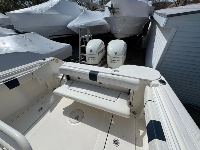 Slide: The Image of 2016 Wellcraft 252 Fisherman boat with dual Evinrude engines, docked and covered. - 15