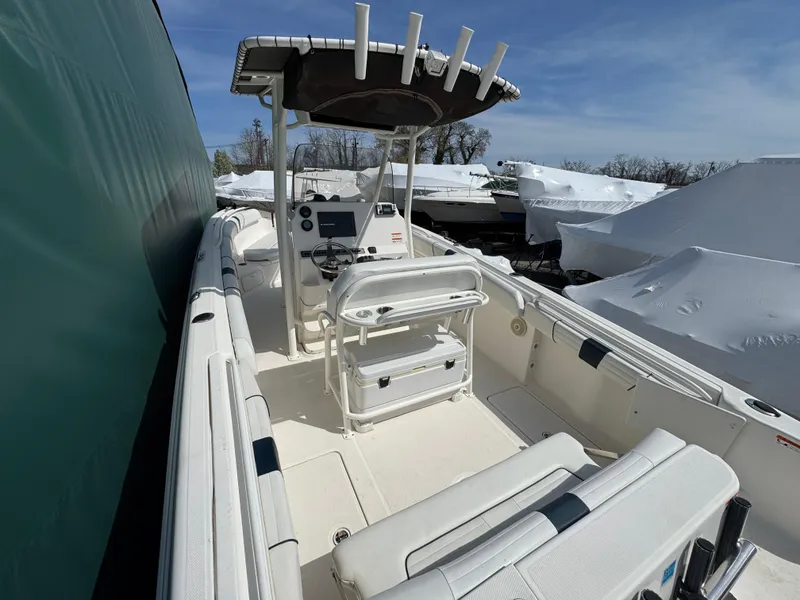 Slide: The Image of 2016 Wellcraft 252 Fisherman boat with T-top and seating, docked outdoors under clear skies. - 16
