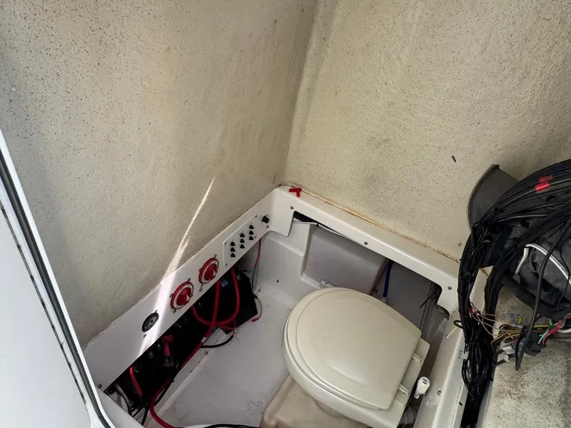 Slide: The Image of Interior of a 2016 Wellcraft 252 Fisherman boat showing a compact marine toilet setup. - 21