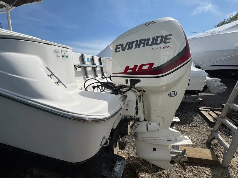 Slide: The Image of 2016 Wellcraft 252 Fisherman with Evinrude E-TEC outboard motor, parked outdoors. - 24