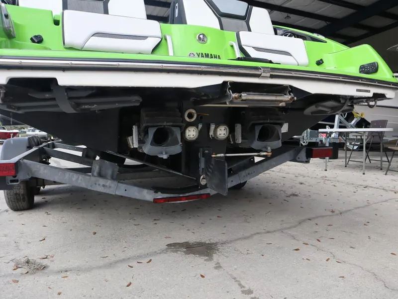 Slide: The Image of 2022 Yamaha Boats 255XD in vibrant green on a trailer, rear view. - 8
